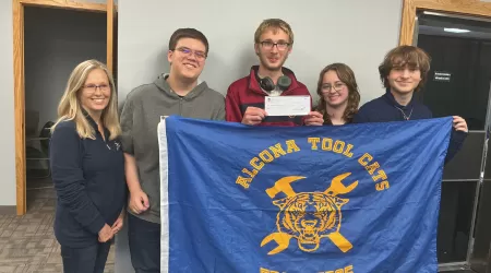AAACU Team members pose with bags of trash they cleaned up in the community.